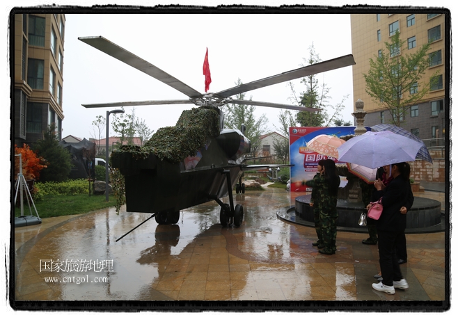 小區(qū)突然出現(xiàn)“飛機(jī)坦克”，其中殲15艦載戰(zhàn)斗機(jī)一架、99式主戰(zhàn)坦克一輛、武直-10武裝直升機(jī)一架，吸引了眾多市民雨中圍觀、合影。